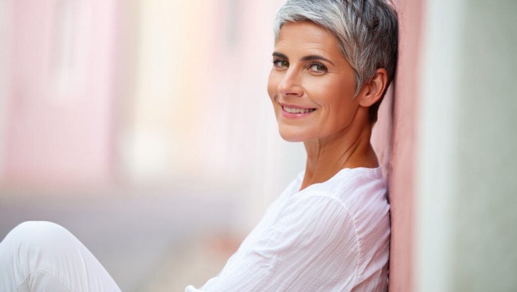 Hormonberatung in den Wechseljahren - sitzende Frau an die Wand gelehnt